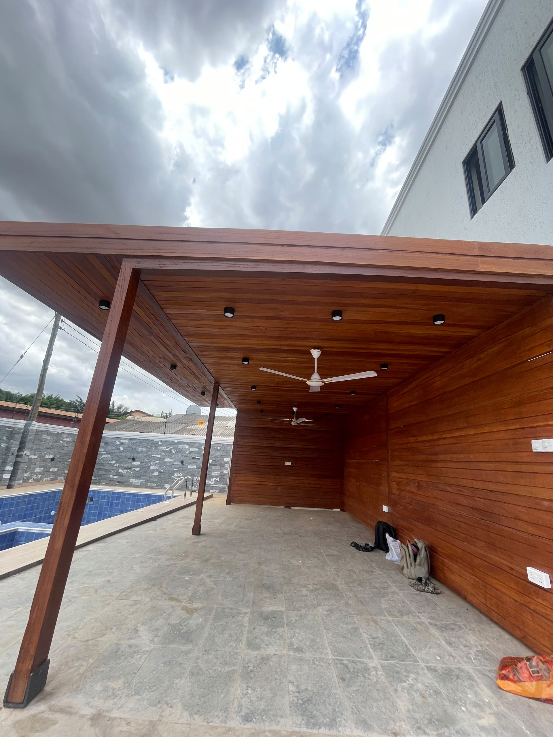 SD Composites hardwood pergola ceiling installation over a residential pool deck in Accra